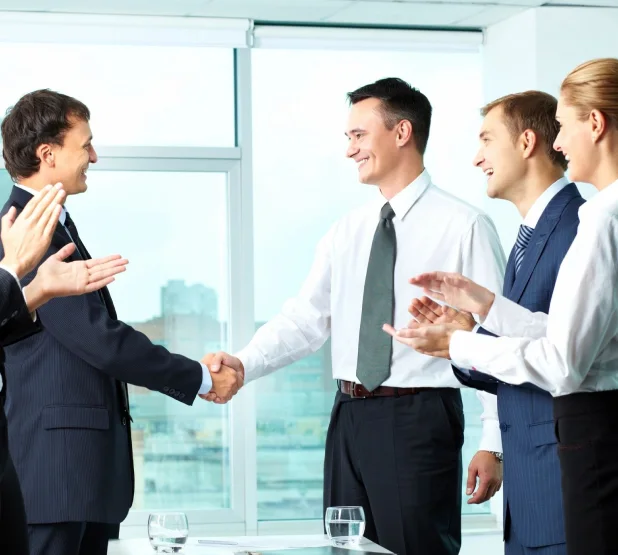 A group of people in suits shaking hands.