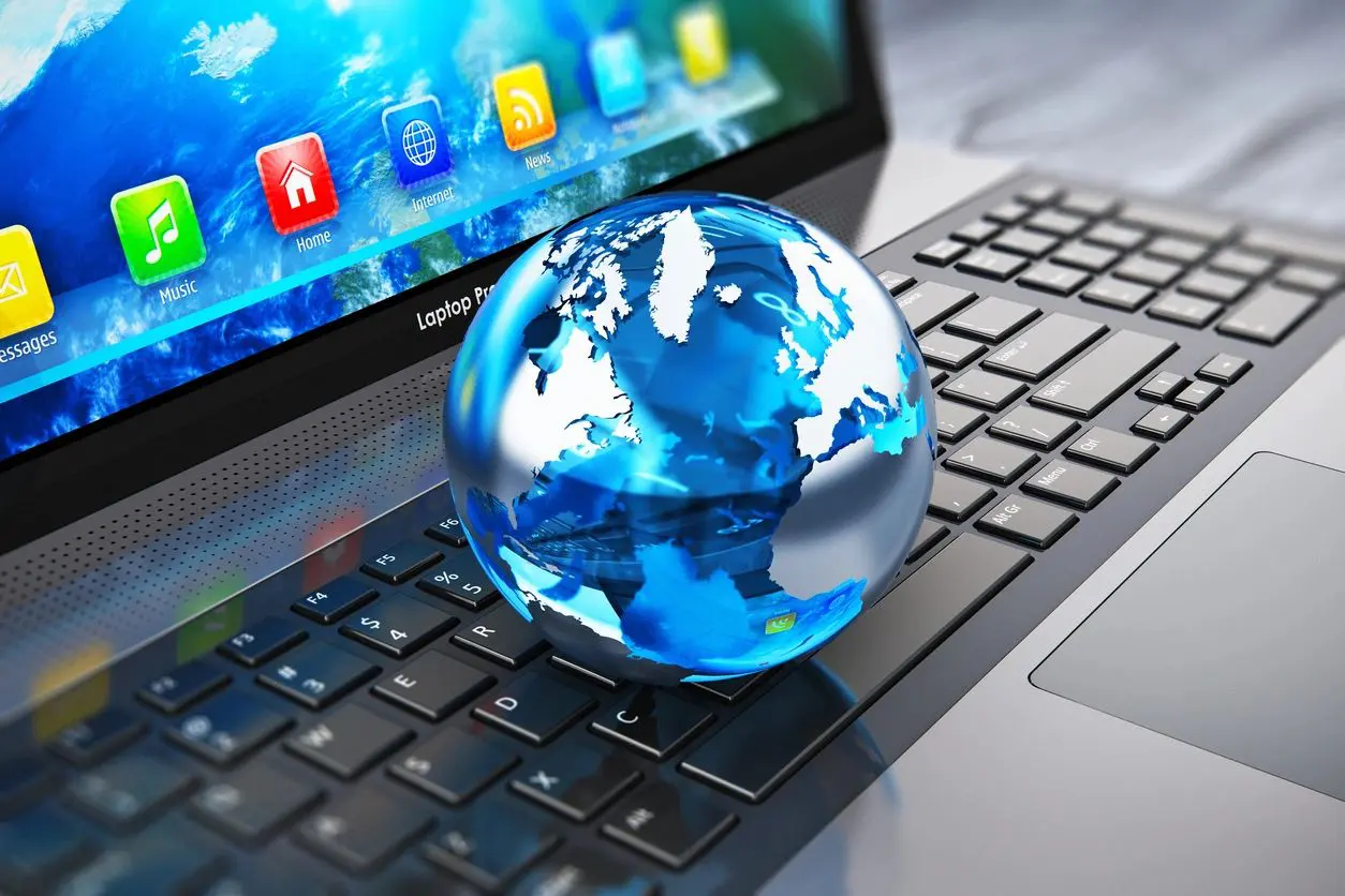 A globe sitting on top of a laptop keyboard.